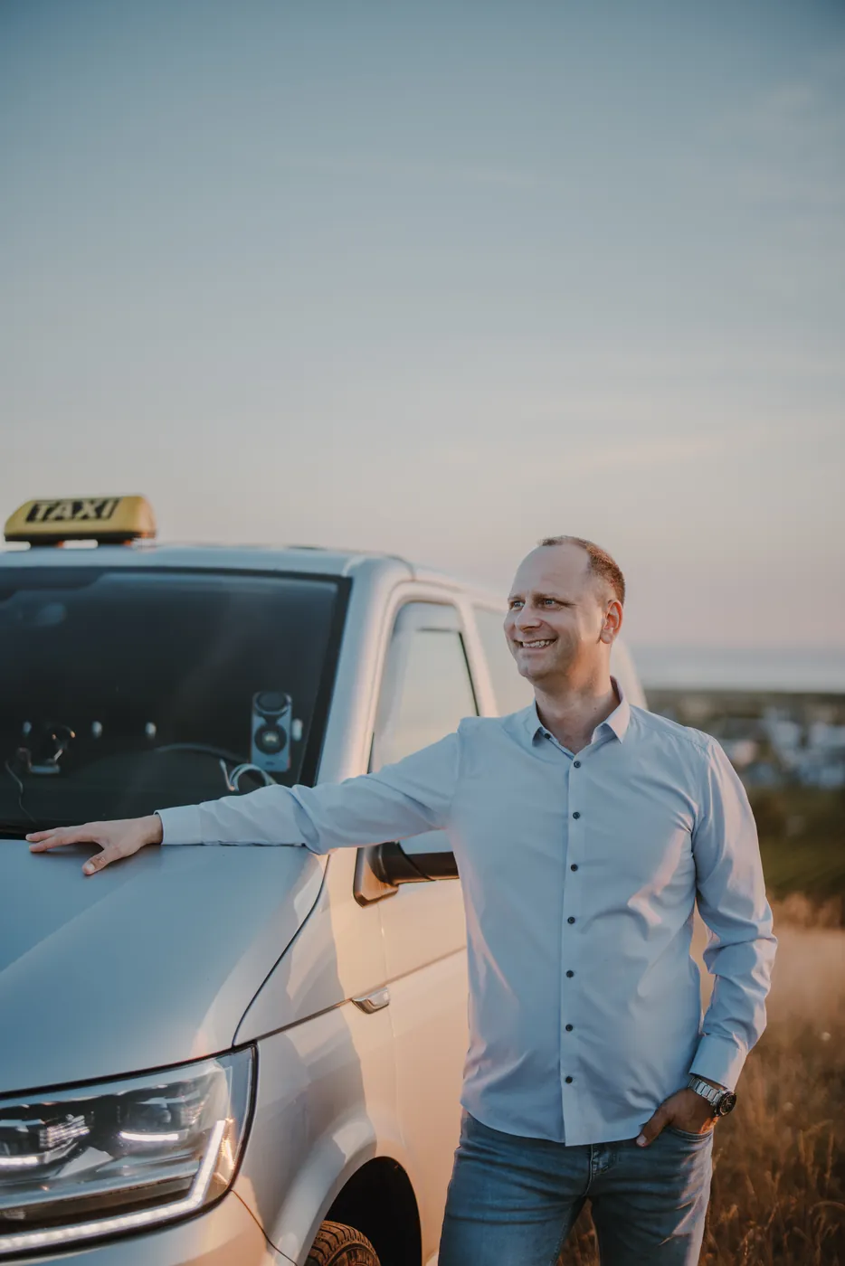 Balazs Kegl, Taxi Kegl Balazs Kegl, Inhaber von Taxi Kegl, lächelnd am Taxi