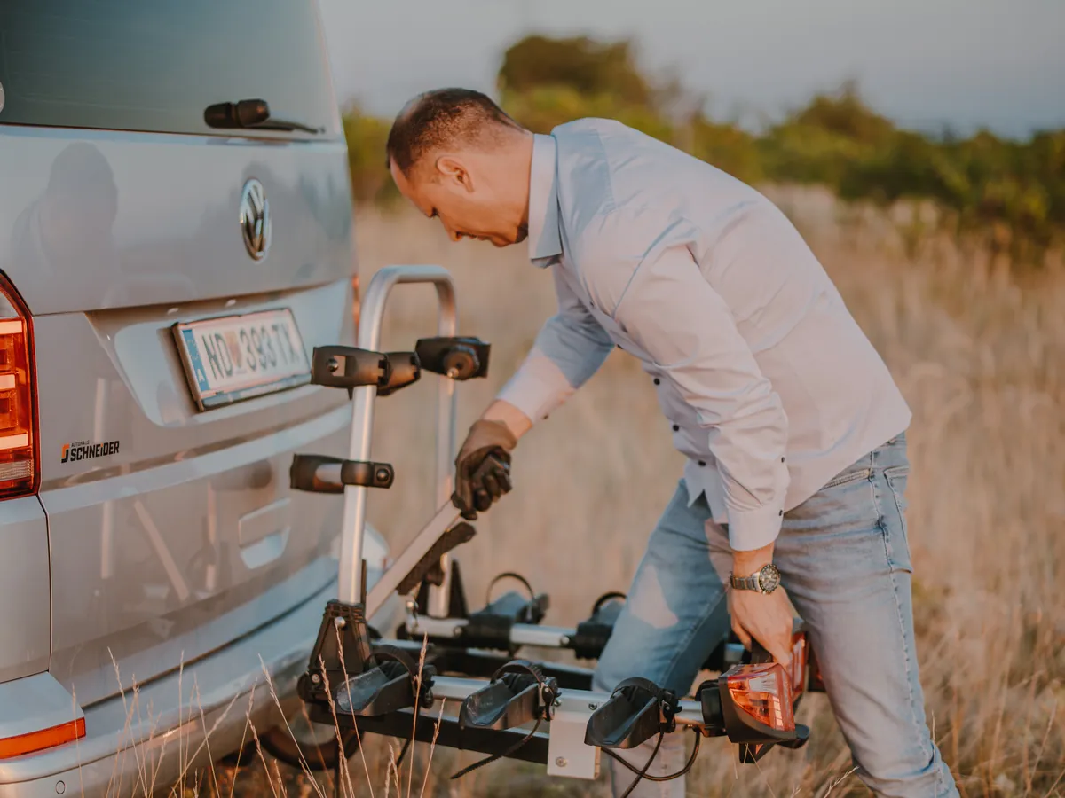 Fahrradtransport mit Taxi Kegl Balazs Kegl befestigt ein Fahrrad am Fahrradträger des VW-Busses