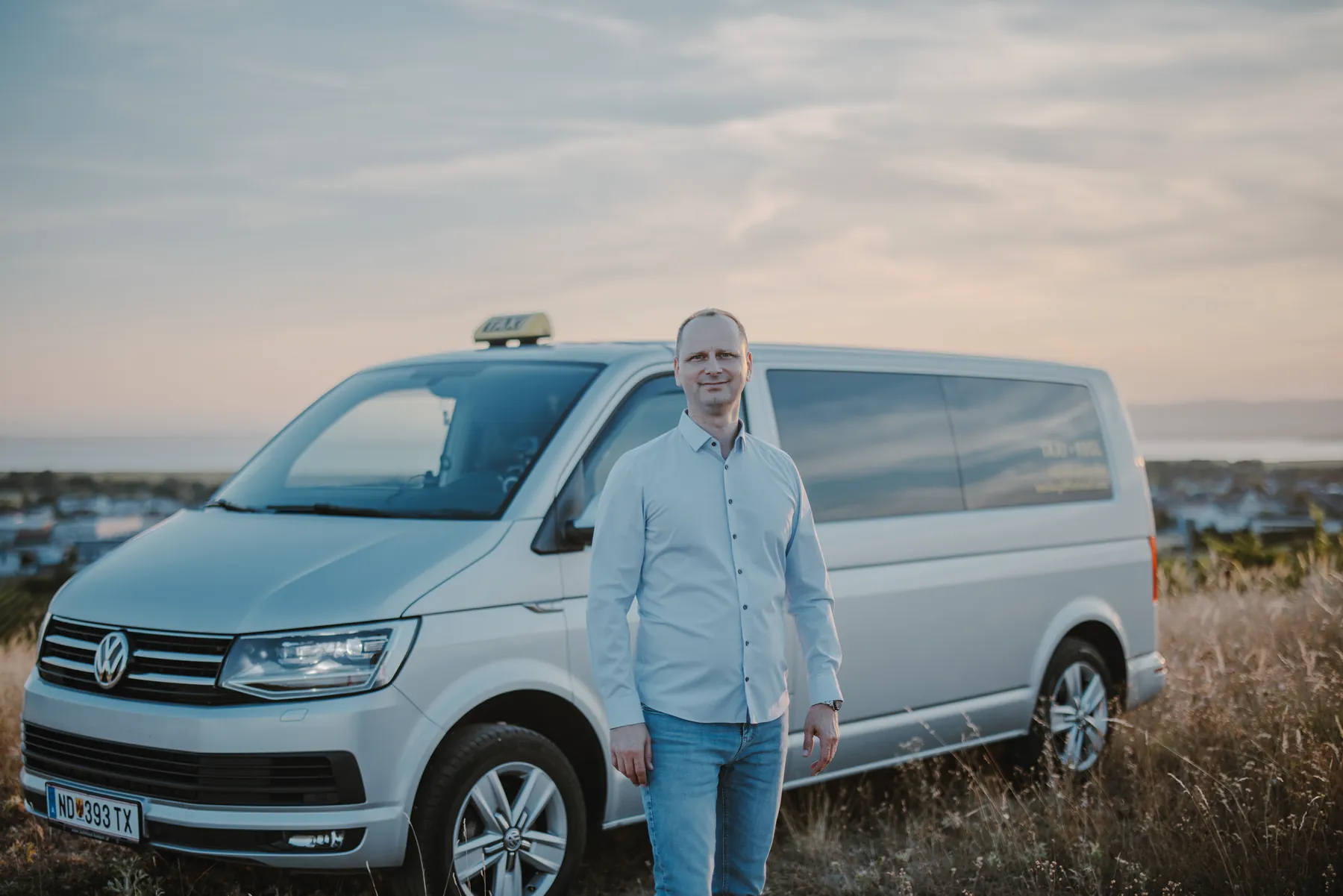 Taxi Kegl in Neusiedl am See Balazs Kegl, Inhaber von Taxi Kegl, vor seinem VW-Bus